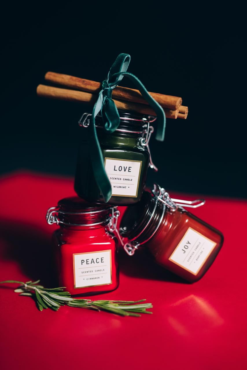 Three scented candles tied with a velvet ribbon and cinnamon sticks
