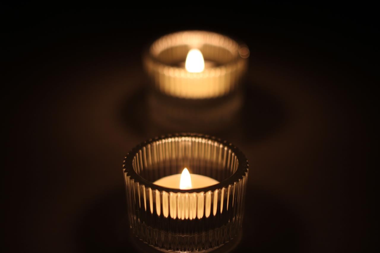 Two tealights burning in ribbed glass holders